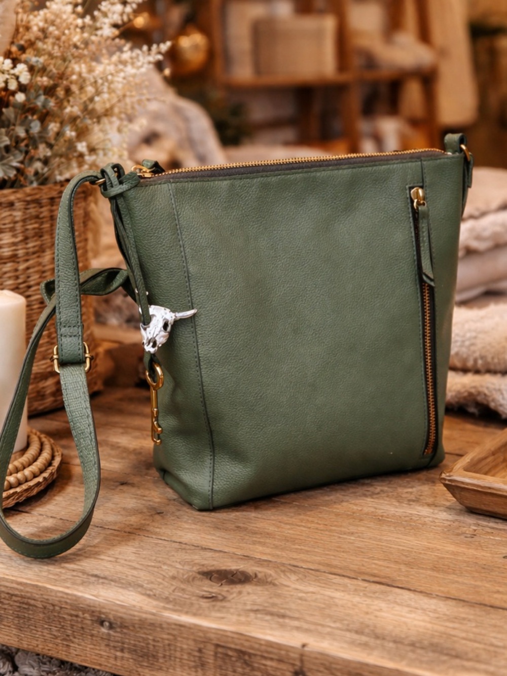 Fossil sage green and brass crossbody bag with key and cow skull charms